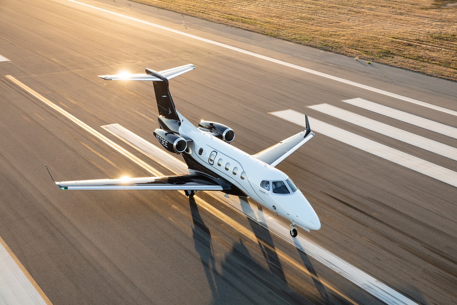 Embraer Phenom 300E light jet on runway at sunset