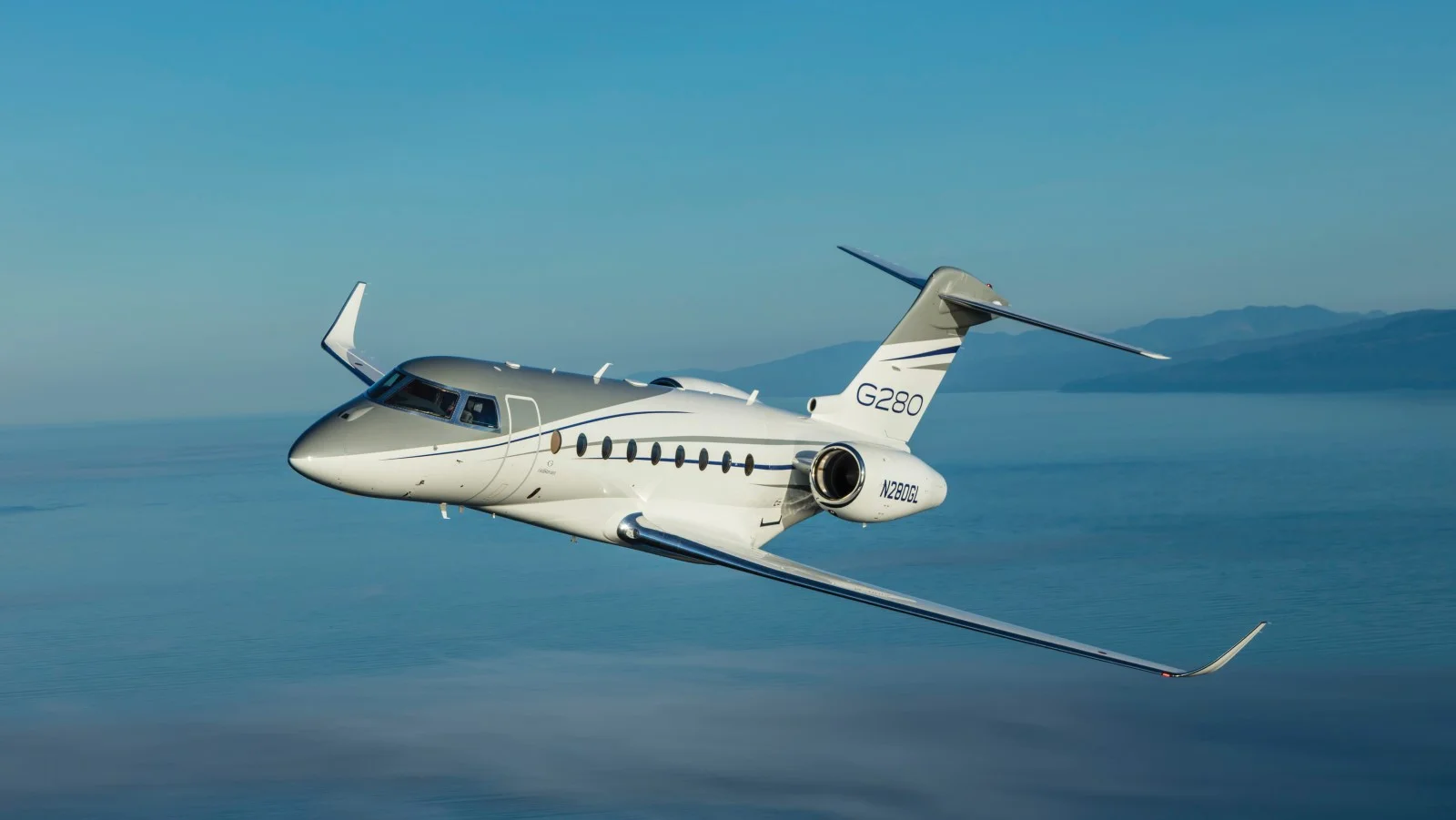 Gulfstream G280 super-midsize jet in flight over water